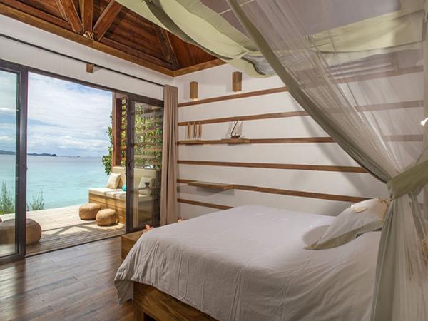 Interno di una stanza con arredamento in legno e grande vetrata vista mare