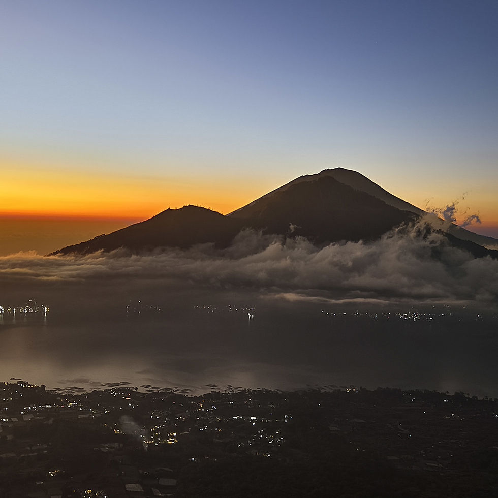 Il sole sorge alle spalle dei coni vulcanici del Batur a Bali, Indonesia