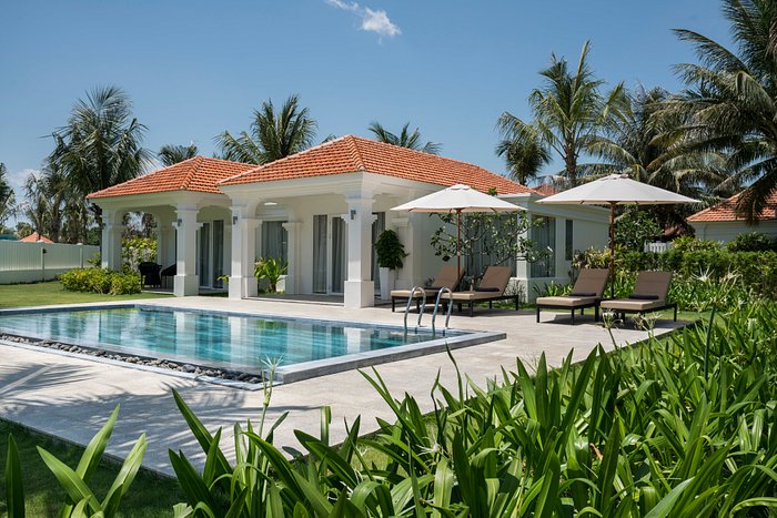 Piscina all’aperto circondata da flora tropicale in resort boutique a Hoi An