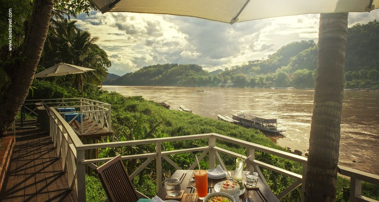 Terrazzo con tavolo preparato per la colazione con vista sul fiume e sulla foresta in Laos