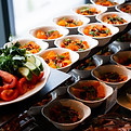 A variety of fresh dishes displayed on a buffet table at a catered event, featuring salads