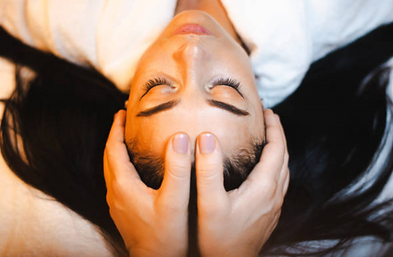 woman relaxing on a spa bed with hands on her forehead in therapeutic way.