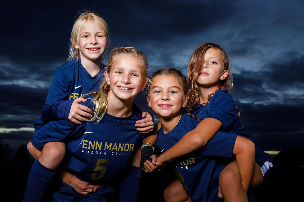 A group of girl soccer players pose for a picture.