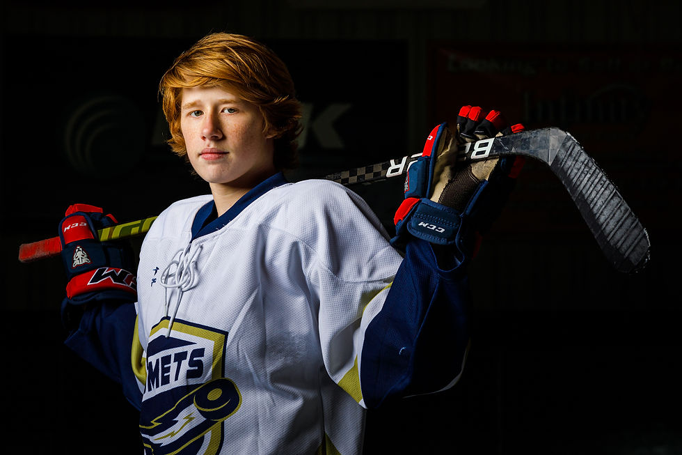 A high school hockey player holds his stick.