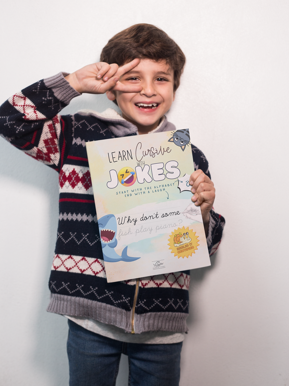 happy-boy-doing-the-peace-sign-holding-a-big-book-mockup-a19220-7.png