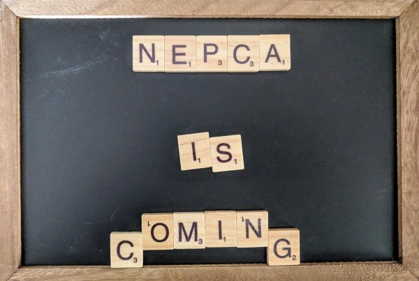 A chalk board with Scrabble letters spelling out "NEPCA is coming" in the center.