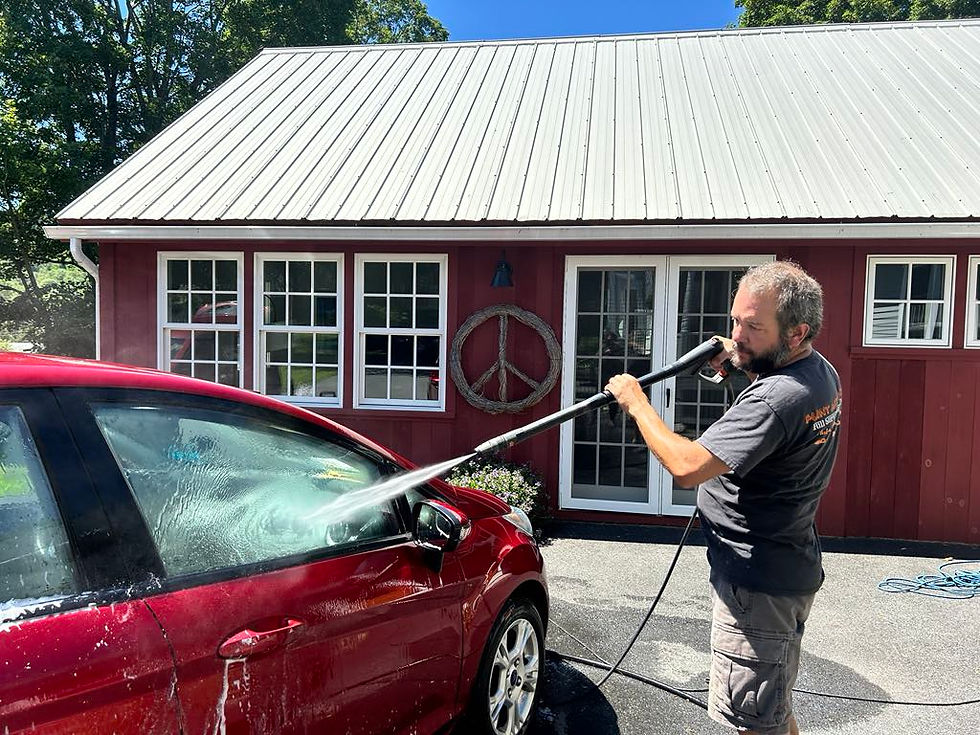 Close-up view of a professional detailer cleaning a car's exterior with a microfiber cloth
