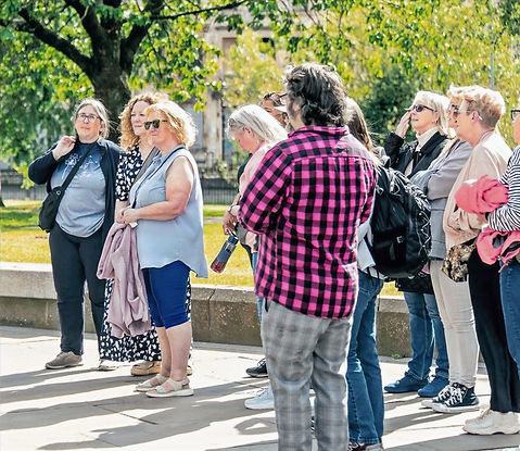 Paisley Tours guide leading a walking tour through historic town centre, engaging visitors with local stories