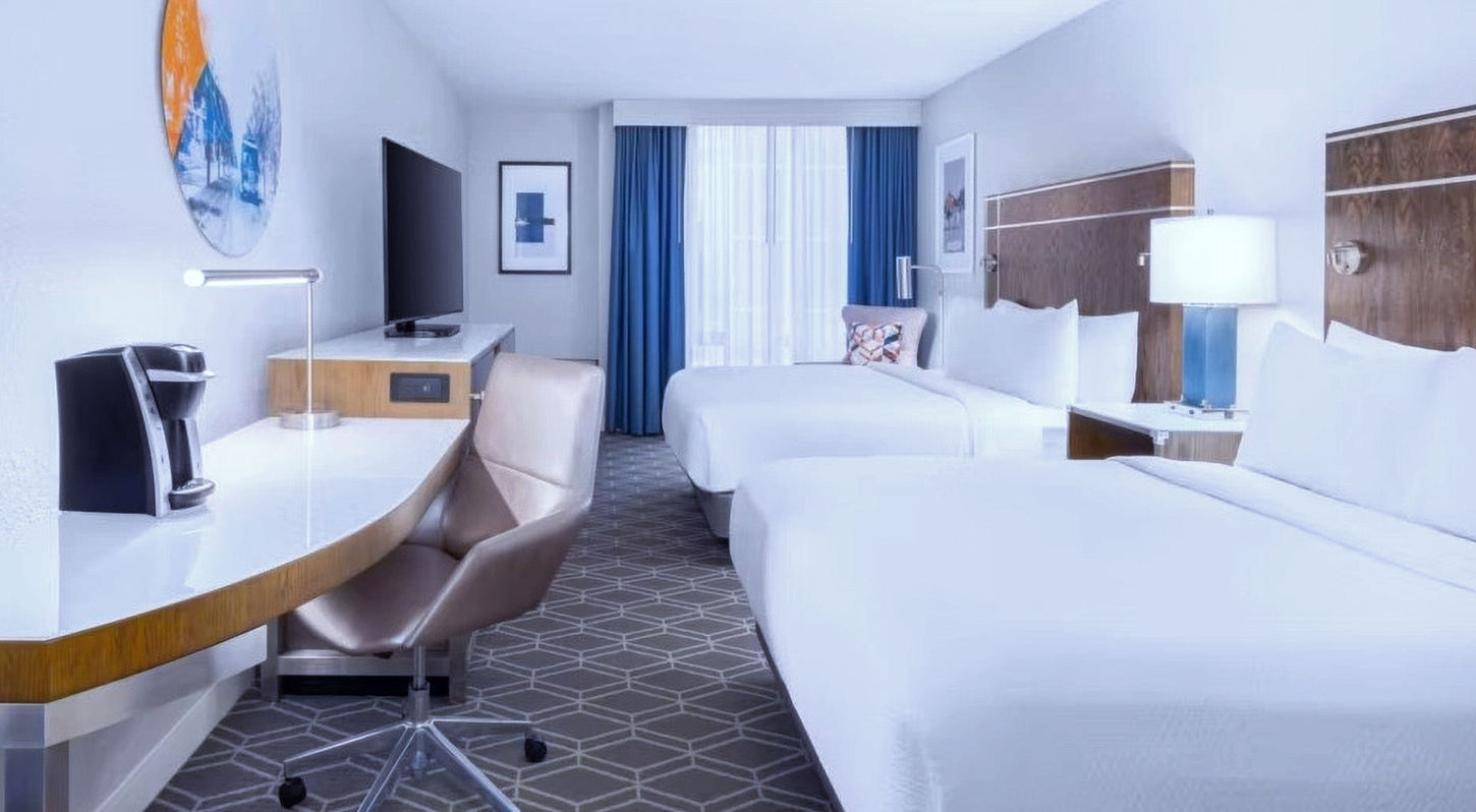 Spacious guest room at Wyndham Jacksonville Hotel with comfortable bedding and modern amenities