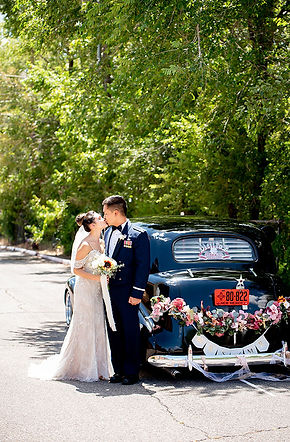 A couple kissing next to their get-a-way car on their wedding day. The wedding was planned by La Luz Weddings and Events a wedding planning business based in Albuquerque, New Mexico and service Santa Fe, the southwest, and destination weddings.