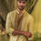 Thumbnail: A person stands in a garden setting, wearing a light green traditional short kurta online with intricate embroidery and gold
