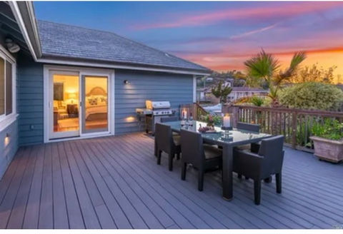 A deck furnished with a table and chairs presents a beautiful sunset view, emphasizing outdoor comfort and quality construction services by Beyond Builders.