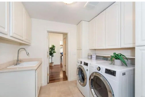  Interior of a laundry room with a washer and dryer, showcasing Beyond Builder's residential construction services.