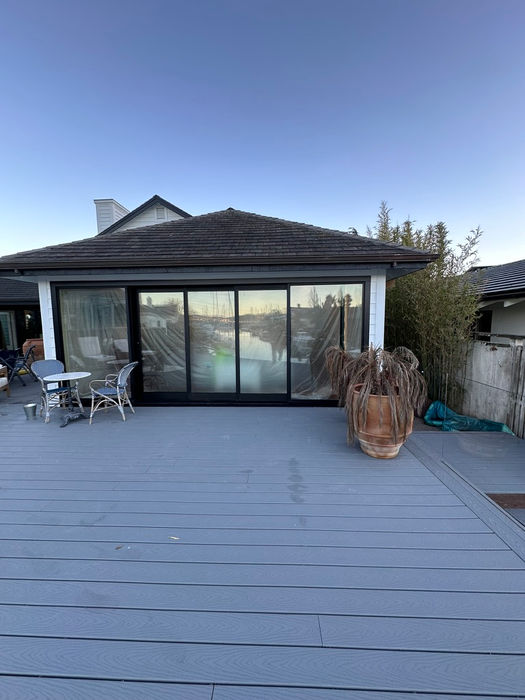 A renovated home deck featuring a patio and a sliding door, enhancing outdoor living space and accessibility.