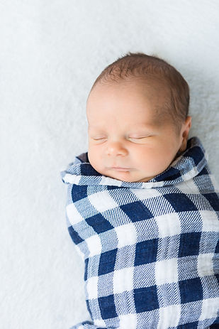 Newborn baby boy tightly wrapped in blue and white swaddle blanket_edited.jpg
