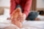 Person massaging tired feet after a long day.