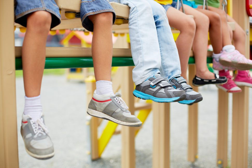 Child trying on supportive sneakers with parent checking fit.