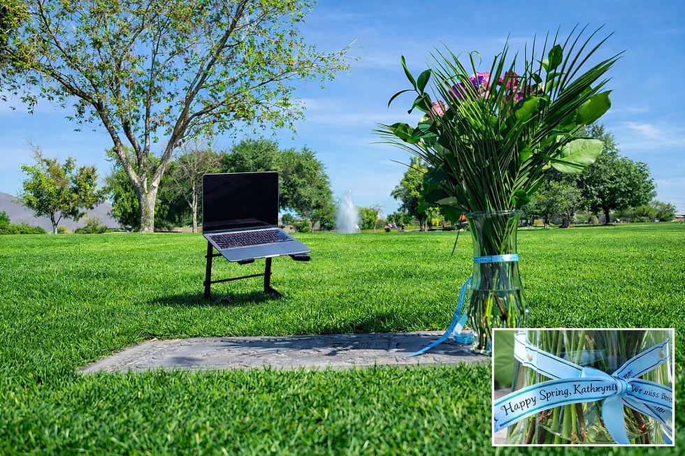 Computer positioned near a cemetery headstone with flowers, set up for a respectful virtual cemetery visit on behalf of a client.