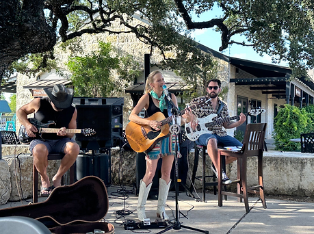 Live Music in Marble Falls, TX. Woman playing guitar and singing under a live oak tree, near Austin