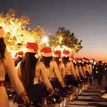 A line of women dressed in band uniform at a Christmas parade in Marble Falls, TX near Austin glamping