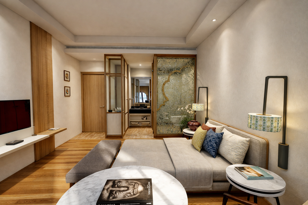 Bedroom interior featuring a seating area, wooden flooring, and a semi-open bathroom with decorative glass partition.