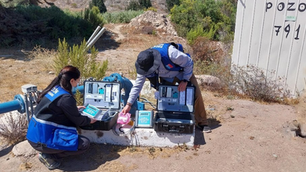 Funcionarios de la DGA realizando inspección y verificación de equipos de monitoreo en un pozo de captación en zona rural, como parte de las fiscalizaciones a derechos de aprovechamiento de aguas.