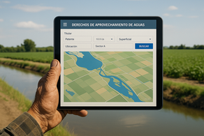 Mano campesina sostiene una tablet que muestra un mapa digital de derechos de aprovechamiento de aguas, con un canal de riego y cultivos verdes al fondo, simbolizando la digitalización de la gestión hídrica.