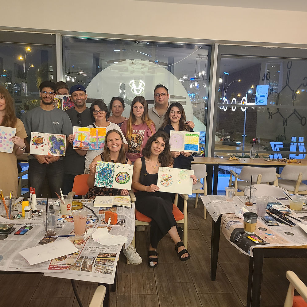 Adults proudly display their artwork after an art class