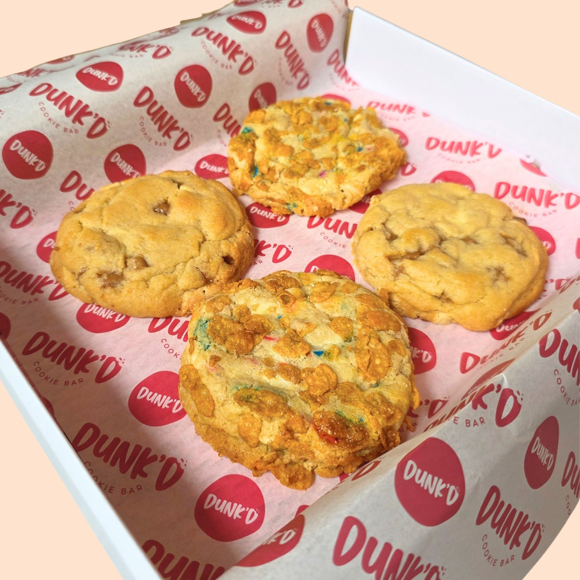 2 cereal milk funfetti cookies and 2 miso, caramel white chocolate cookies in a box