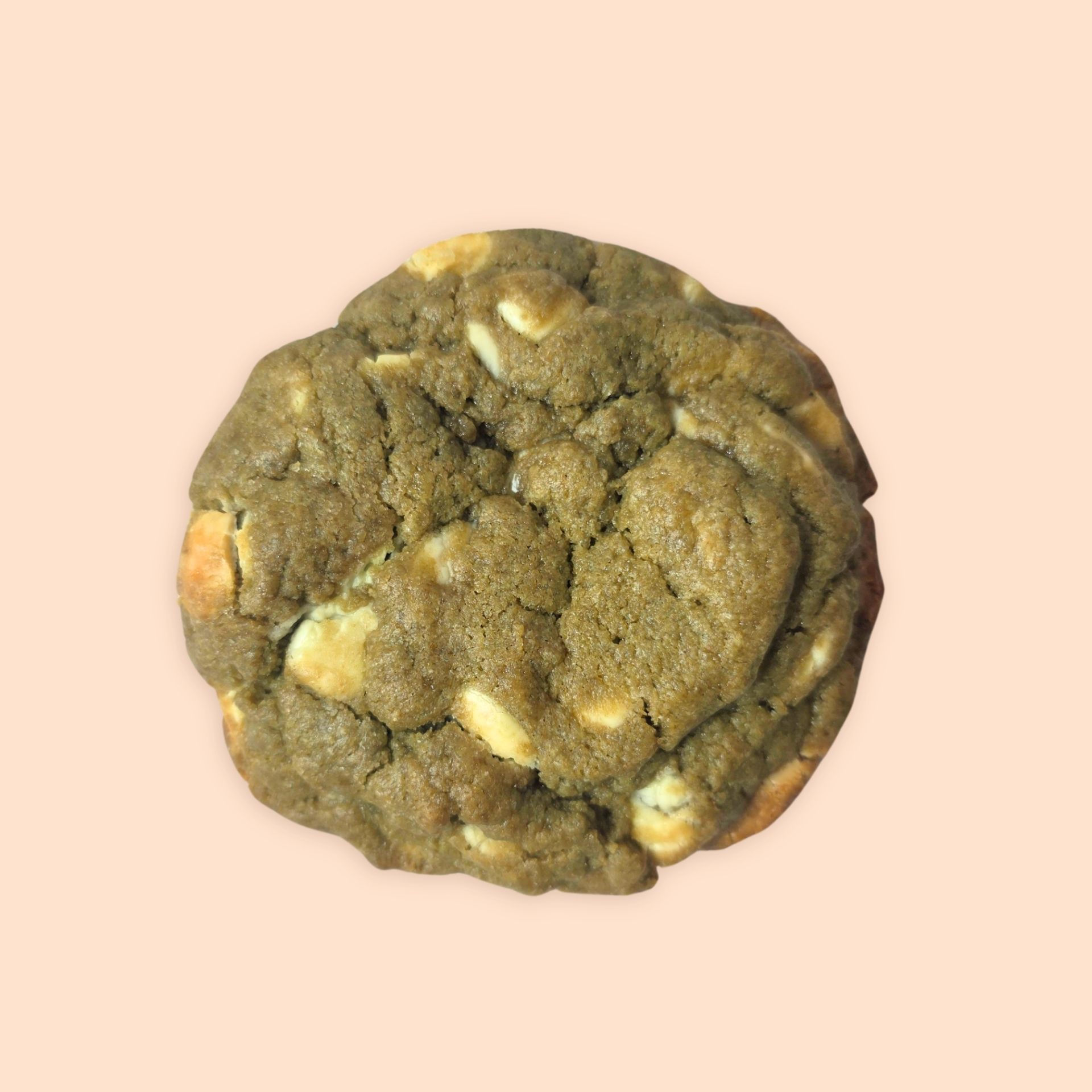Green matcha cookie with white chocolate on a cream background