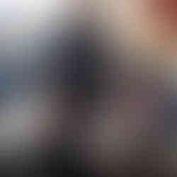 Young man cooking food in a frying pan with printed documents on table.