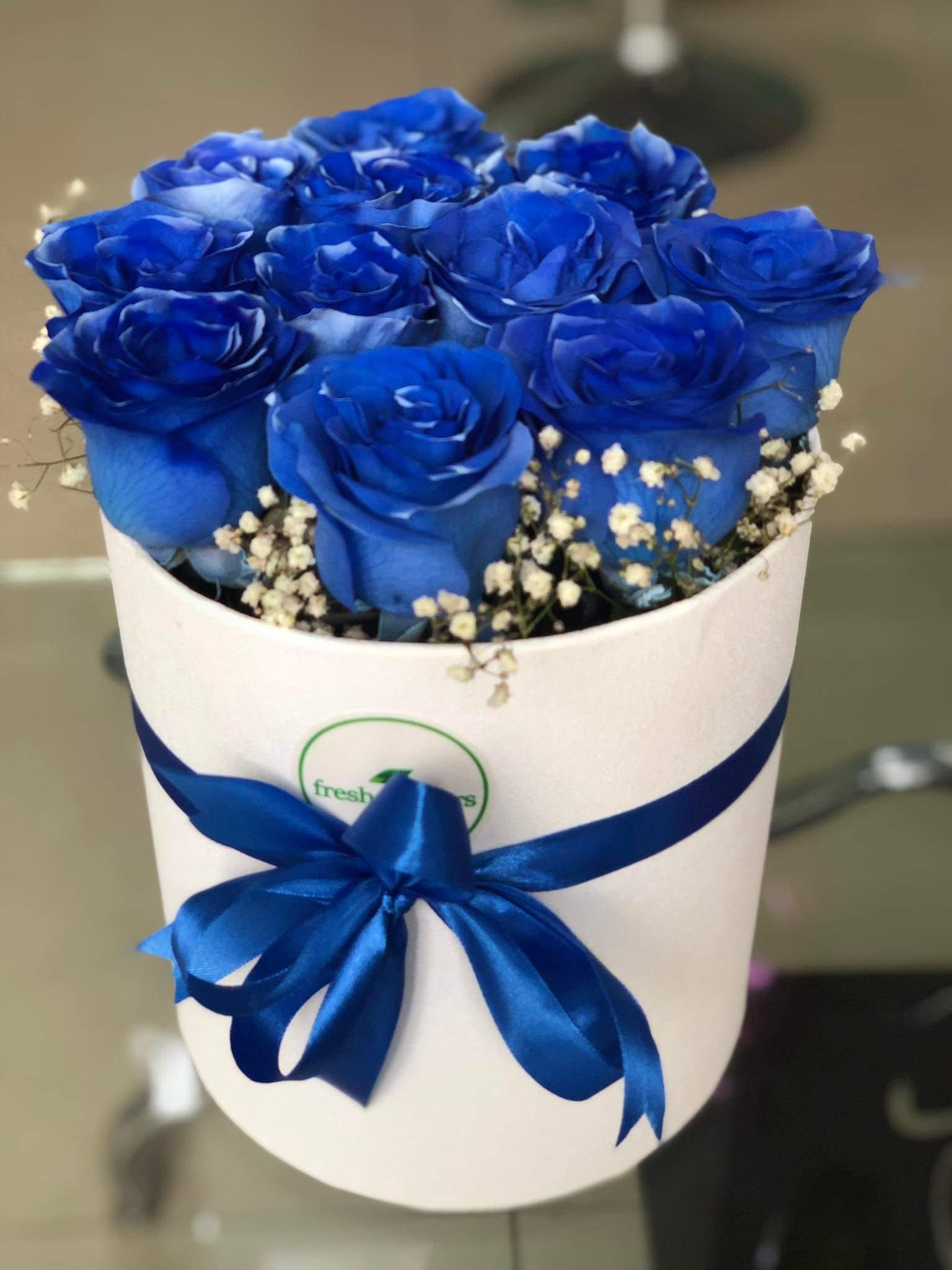 ლურჯი ვარდების თაიგული თეთრ ყუთში, ლენტით