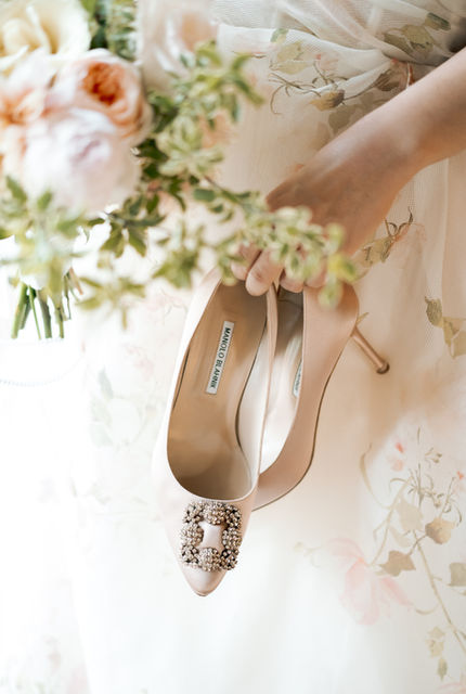 Bride’s Manolo Blahnik shoes with intricate details placed on a delicate veil posing at the San Ysidro Ranch in Montecito 
