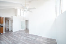 Interior professional wide angle photograph for a modern, open-plan living room combined with kitchen showcasing the room's clean lines, minimalist style, neutral color palette, and stylish blend of functionality and style, perfect for inspiring home decor, residential photography, room design, and real estate photography.