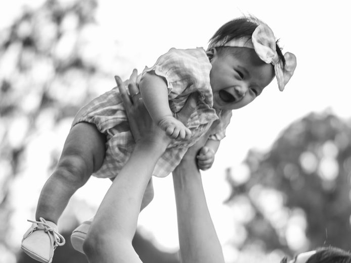 Editorial motherhood photography in Santa Barbara by Anna Kreative Studio, emotional mother and baby portrait captured by one of the best family photographers in California, Black and white candid photograph of a mother lifting her baby in her arms with soft natural light, emotional lifestyle