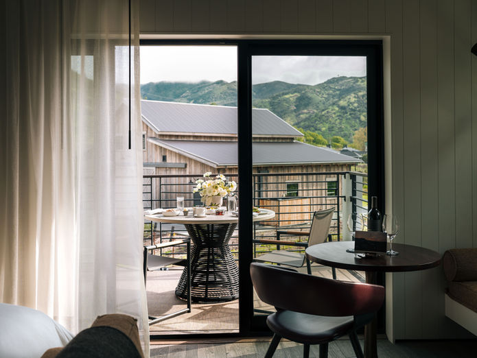 Indoor-outdoor suite with mountain view balcony and breakfast table in luxury hotel setting