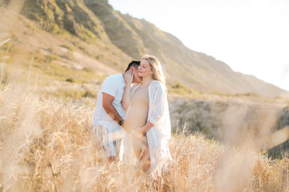 Pregnant couple enjoying each other time on the beach, expecting their new baby to born in a couple of months. Sunset beach maternity photos in Honolulu. Stylish maternity portrait for a young mother to be in Honolulu. Recommended outfits to wear for a maternity photo session at the beach in Hawaii. 