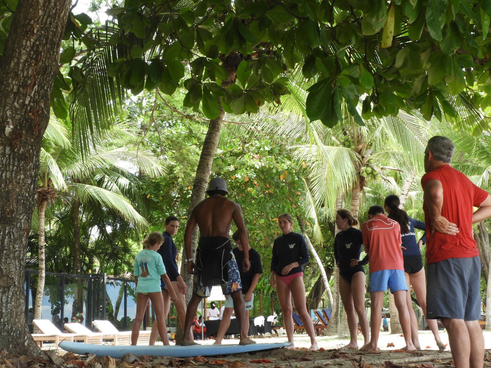 Surf lesson students and instructors with surfboards on Tamarindo beach, Costa Rica