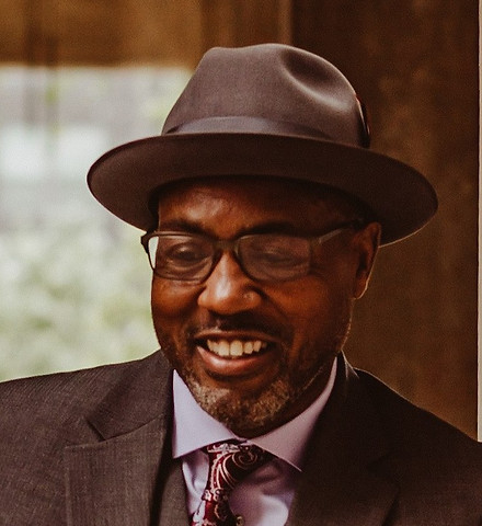 Professional headshot of Helon Belton, licensed therapist in business attire. 