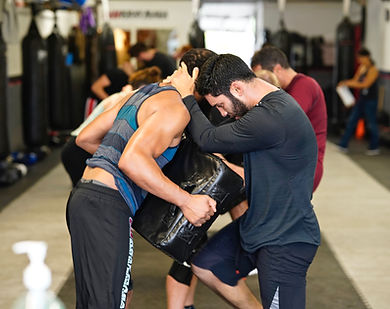 male kneeing heavy pad held by partner
