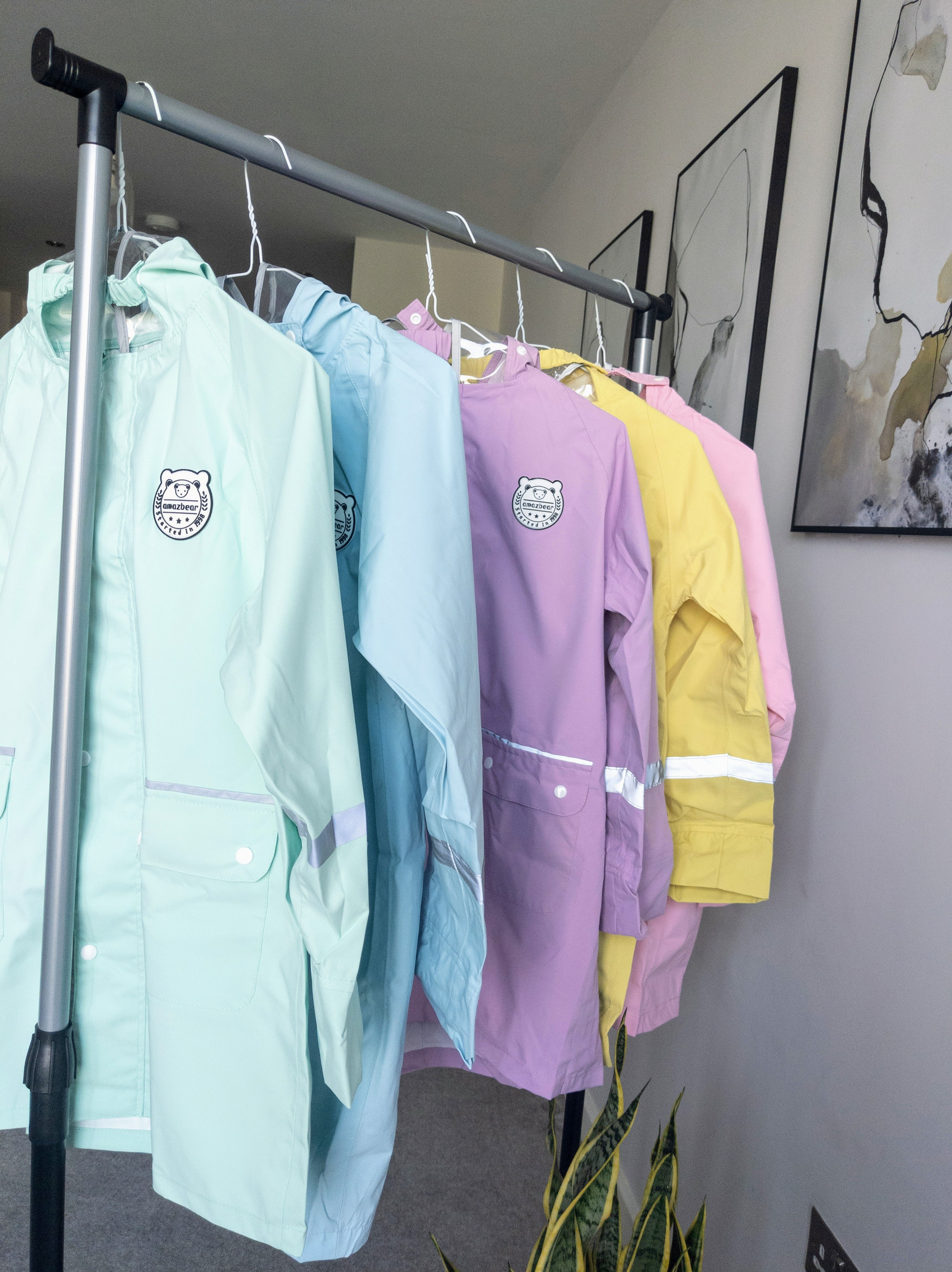 Colorful raincoats hanging on a rack with visible text, Mini-me Bundle beanie, Bold Kidswear.