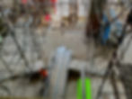 Worker with metal beams on a scaffolded construction site.