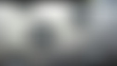 Black graffiti icons on a textured white wall: smiley faces and thumbs-up symbols, with no visible text.