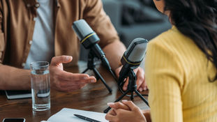 Two podcast hosts recording an episode