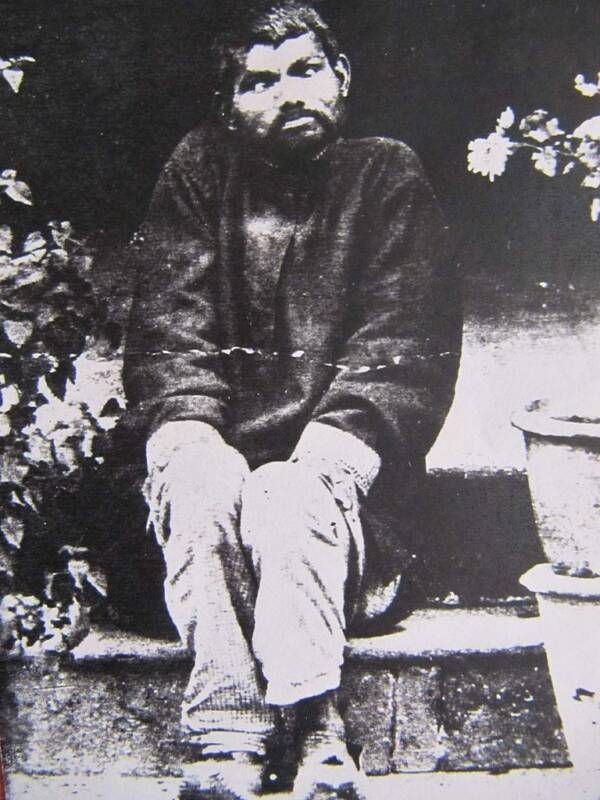 otografia storica di Dina Sanichar, noto come il "ragazzo lupo" dell'India. La foto fu scattata tra il 1889 e il 1894, durante il periodo in cui viveva presso l'orfanotrofio di Sikandra ad Agra. In questa immagine, Dina è ritratto seduto, con un'espressione distante e un portamento che riflette la sua difficile integrazione nella società umana.