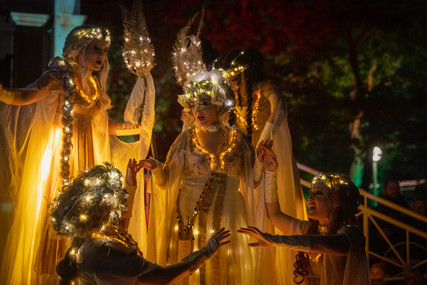Musen Performance Stelzen Musiktheater Walk Act, Künstlerinnen als griechische Göttinnen tanzen und singen in weißem golden leuchtendem Jugendstil Gewand und funkelndem Kopfschmuck