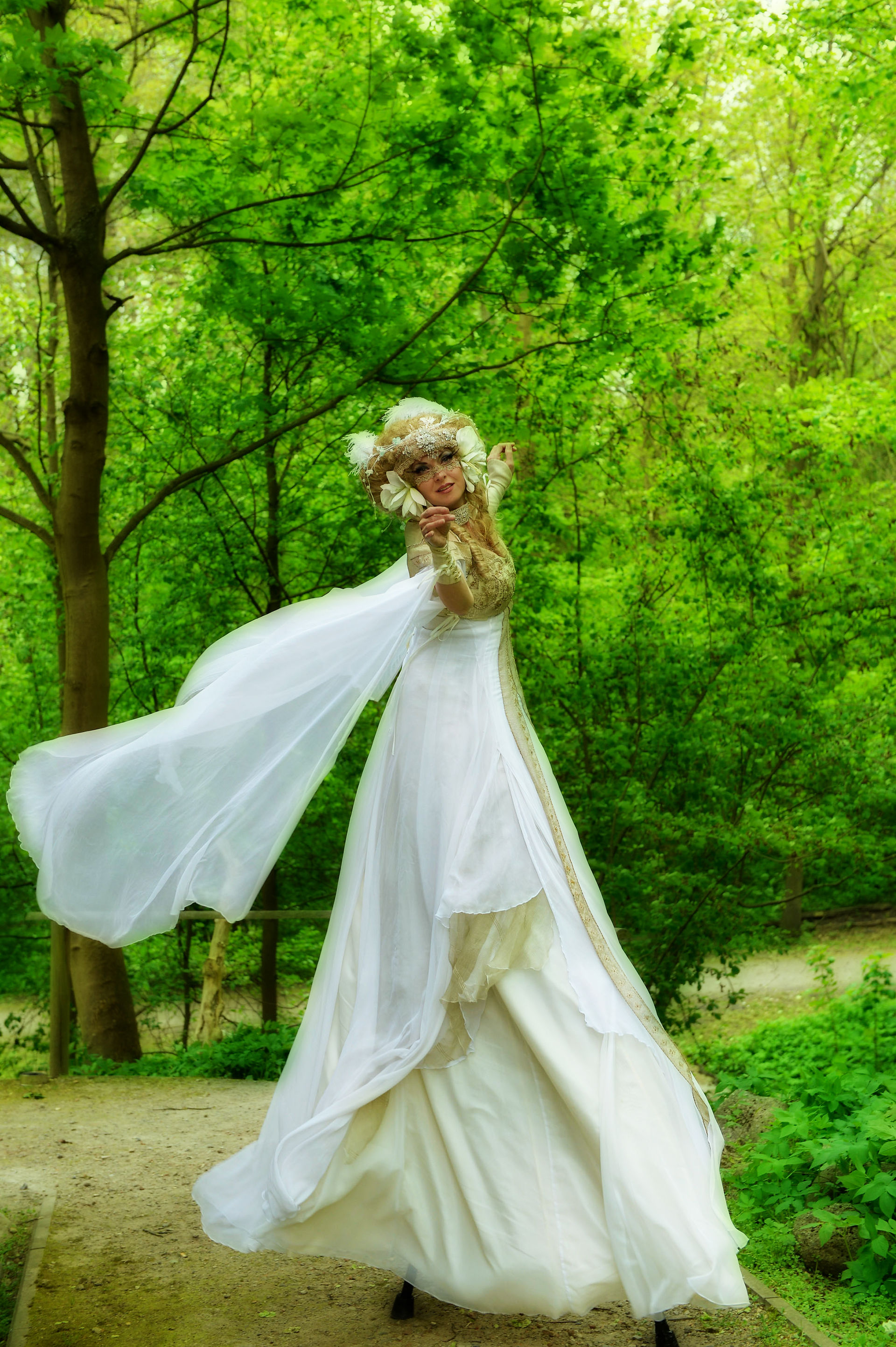 Musen Performance Stelzen Musiktheater Walk Act, Künstlerin als griechische Göttin in der Natur tanzt im Jugendstil Gewand und Kopfschmuck, Ihre Seidenärmel schweben in der Luft