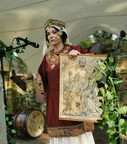 Roswitha (Hrotsvit) von Gandersheim, historische Walk Act, erste bekannte deutsche Dichterin aus dem 10. Jhdt., Theater, Gedicht, Vortrag, Lesung und Walk Act in früh mittelalterlichem Gewand, byzantinische Mode in roter Seide mit Stickereien, aufwendigem Hals- und Schapel Kopfschmuck byzantinische Mode in rot und gold, hält Kupferstich von Dürer hoch, in dem sie portraitiert ist und  ihr Buch "Gesta Oddonis" über die Taten Otto I des Großen. bei Veranstaltungsreihe "Des Kaisers letzte Reise"