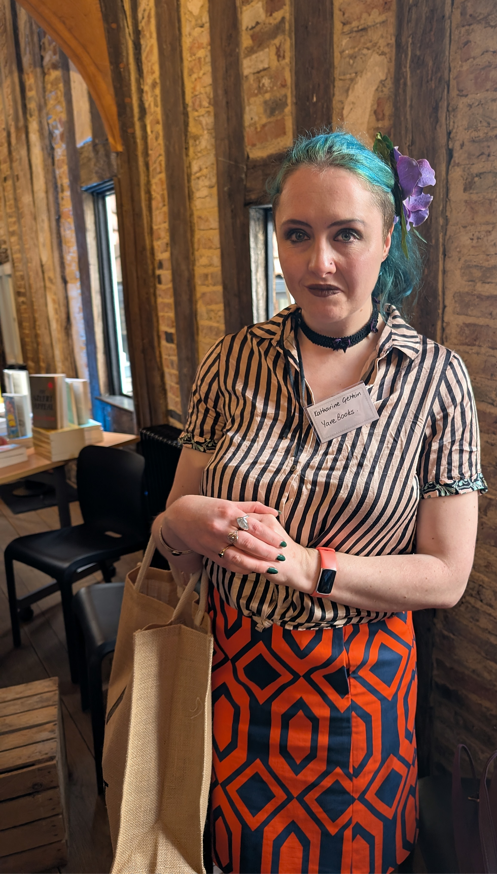 A blue haired woman posing at a promotional book event.