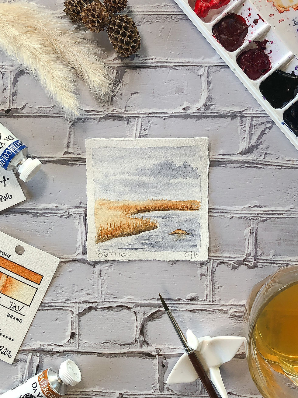 Thumbnail: watercolor painting of water surrounded by golden grasses flat lay with artist palette